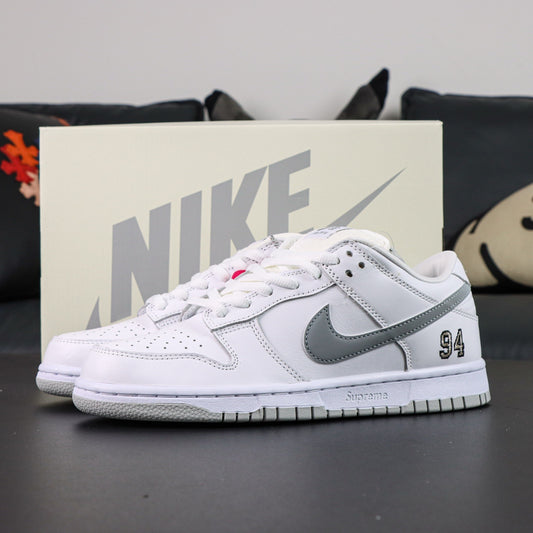 Nike SB Dunk Low Supreme 94 White Metallic Silver sneaker featuring a white and metallic silver colorway.